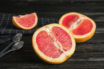 Fresh tasty grapefruits on dark table, closeup