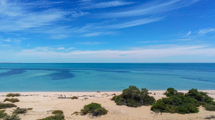 Young couple sitting at empty beach in Shark Bay Western Australia
