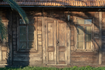 Facade of an old wooden house. Background of the wooden wall of the house