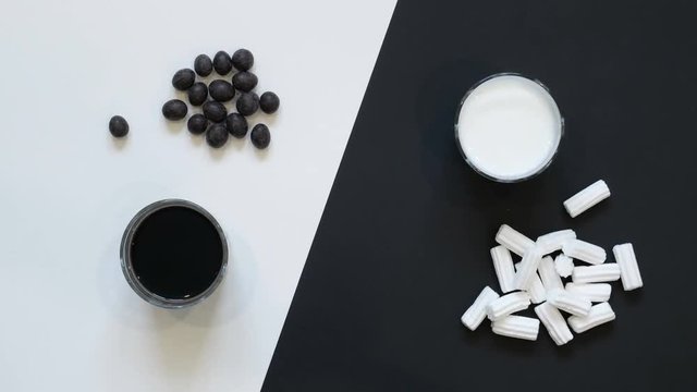 Breakfast. Clouse-up.  Glass of kefir, glass of coffee, peanuts in chocolate and handful of souffle on black and white background. Top view on breakfast.