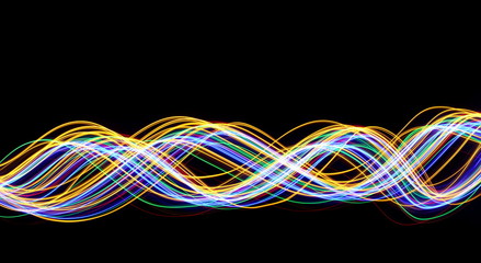 Multi color light painting photography, long exposure, gold, red, green and blue waves of vibrant color against a black background
