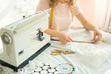 female seamstress designer at work at the table near the sewing machine