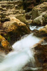 The stream of water in the river flowing between the rocks in the mountains national park