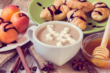 Breakfast of coffee, croissants, apricots, honey, cinnamon and anise
