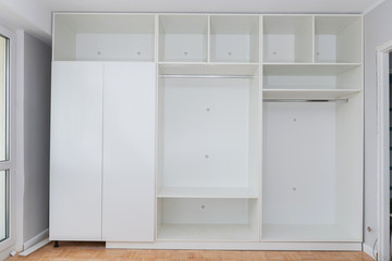 Fototapeta na wymiar Installation of new wardrobe made from white chipboard. Horizontal image