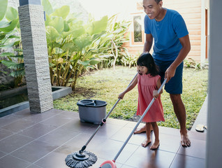 little girl help her daddy to do chores at home - obrazy, fototapety, plakaty