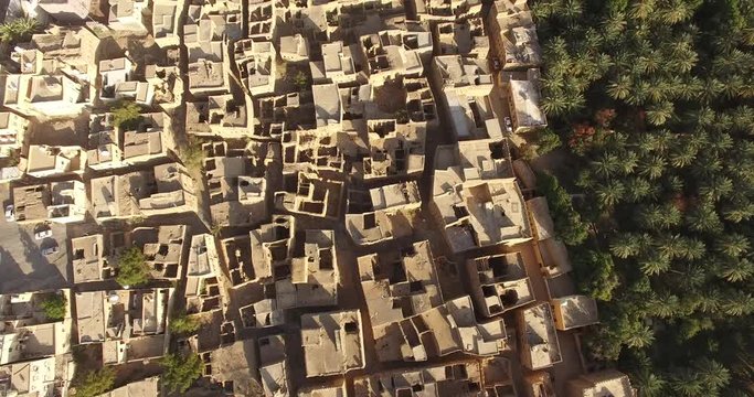 Top aerial 4K view on the traditional regional architecture of the Middle East. Desert valley with mud brick houses in a village.