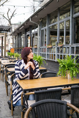 Young lady with long hair sitting alone in cafe