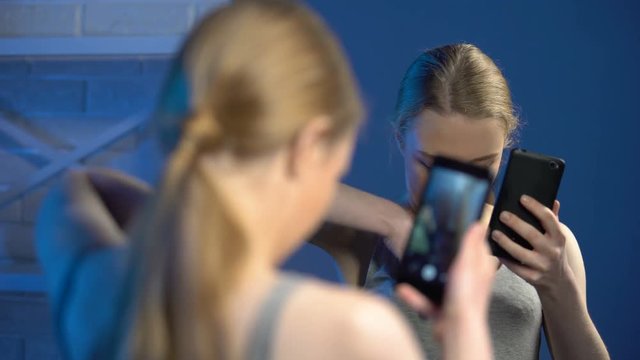 Teenager making fake breasts and taking selfie in mirror, adulthood imitation