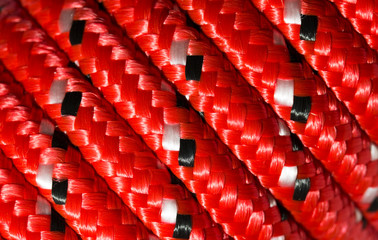 Close up detail of a coiled red nylon rope to make an abstract textured background © Helen Davies