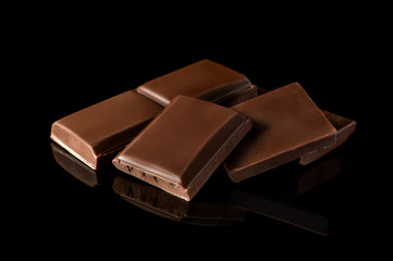 Pieces of chocolate bar on black.