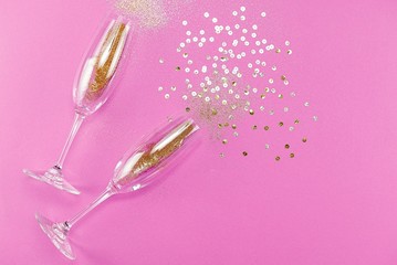 Champagne glasses with splash of golden confetti. Top view. Cele