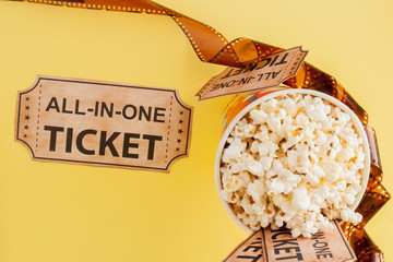 Movie tickets, film strips and popcorn on blue background. Copy space for text