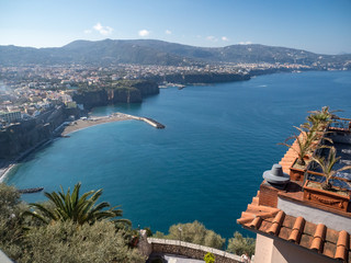 Amazing aerial view of coastline Sorrento city and Gulf of Naples - popular tourist destination in Italy. Sunny summer day with blue sky, clear sea and green mountains. Italy, april 2019