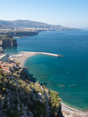 Obraz premium Amazing aerial view of coastline Sorrento city and Gulf of Naples - popular tourist destination in Italy. Sunny summer day with blue sky, clear sea and green mountains. Italy, april 2019