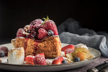Gourmet brioche french toast with berries and marshmallows. Dark background. Horizontal. Copyspace.
