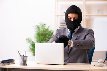 Male gangster stealing information from the office 