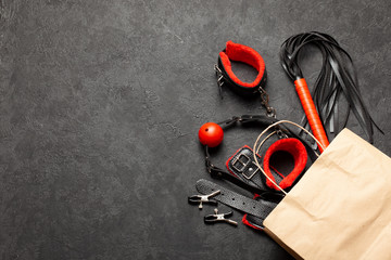 BDSM sex toys for adults. Shopping bag from a sex shop with a whip, gag, handcuffs and leather...