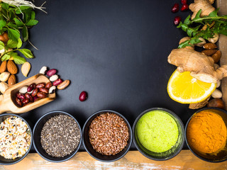 Superfoods on dark wooden table with space for text