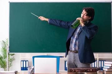 Male teacher drinking in the classroom 