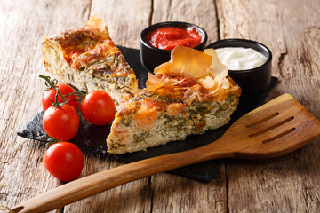 Fish pie with tomatoes, cheese and herbs close-up on the table. horizontal