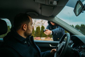 Armed bandit hijacking a middle-aged man's car.