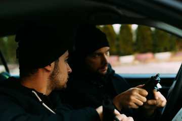 Thieves parked in an ally waiting and planning the way they will rob their target.
