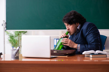 Male teacher drinking in the classroom 