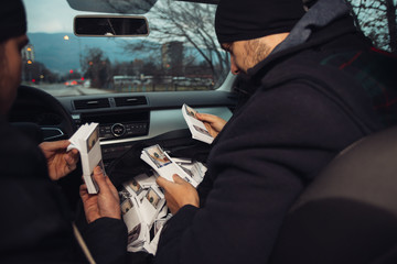 After the successful bank robbery, the thieves are sitting in the car showing off their money and...