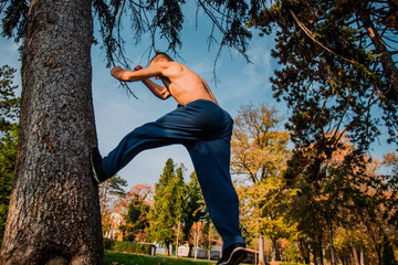 Parkour man climbing on tree while execising parkour