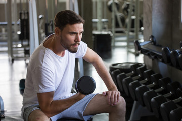 fitness man doing exercises sitting with weight lifting dumbbells in gym . sport young male  training .work out healthy