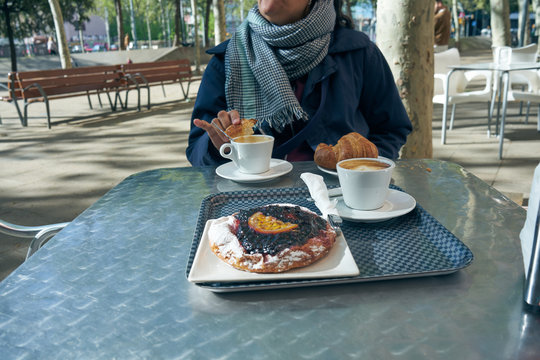 Breakfast on a sunny winter morning, in a terrace of a bar, drinking coffee with croasan and blueberry pie