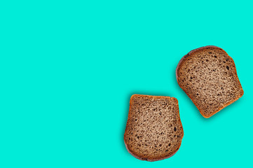 Two rectangular pieces of fresh rye bread on green table on kitchen. Copy space for your text. Top view. Dieting concept