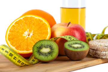 Apple, orange, kiwi with measure tape on white background