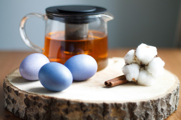 lilac painted eggs on a tree of tea on a light background of Easter