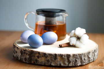 lilac painted eggs on a tree of tea on a light background of Easter