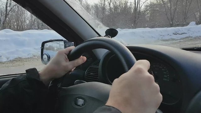 lifestyle bearded man driving a car on a Sunny winter day in the mountains