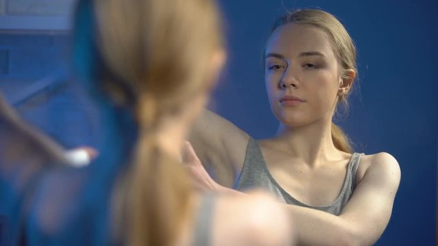 Attractive woman spraying deodorant underarm, personal hygiene, freshness