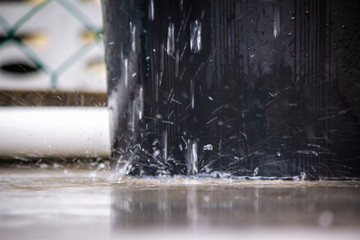 Close up of splashing water flowing out of a bucket at low shutter speed.