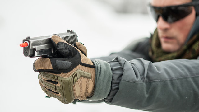 Close-up view of shooter hands holding gun with safety stick