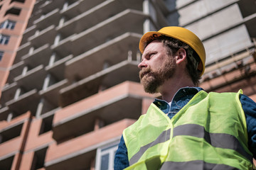 mustache brigadier. bearded foreman in a yellow helmet