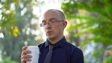 Late 20s Caucasian Office Worker Drinking Coffee During Lunch Break in Park