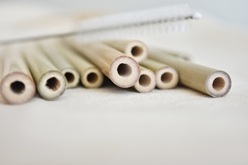 No plastic, natural reusable bamboo straws, eco friendly, zero waste. Close up view on cotton tablecloth.