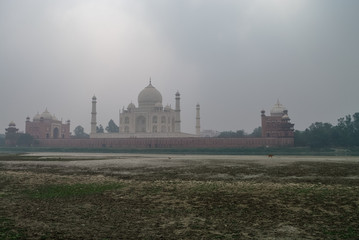 Fototapeta na wymiar Taj Mahal and Yamuna river view in morning fog from Mehtab Bagh or The Moonlight Garden, Agra, India