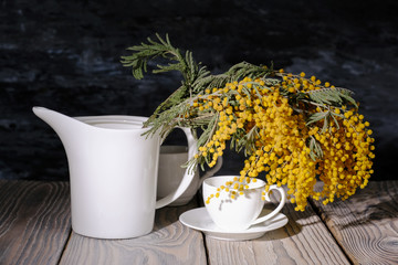 Still Life mimosa and tea set on the table in the sunshine.