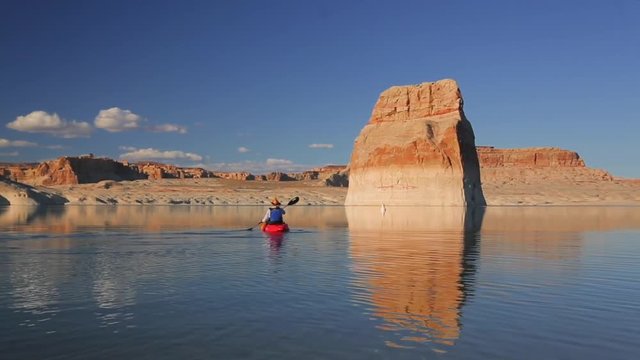Back view of an adult sitting on single kayak. Male having solo boat jorney along the Lake Powell. Grand Canyon, AZ.