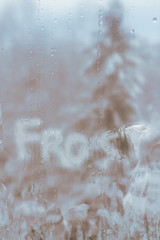 Inscription frost on frozen cold of the winter window