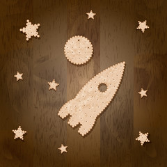 Rocket, moon and stars in the form of cracker cookies on a wooden background