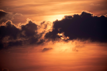Fototapeta na wymiar Cloudy sunset with sun behind cloud.