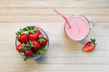 Glass with tasty strawberry smoothie on wooden table